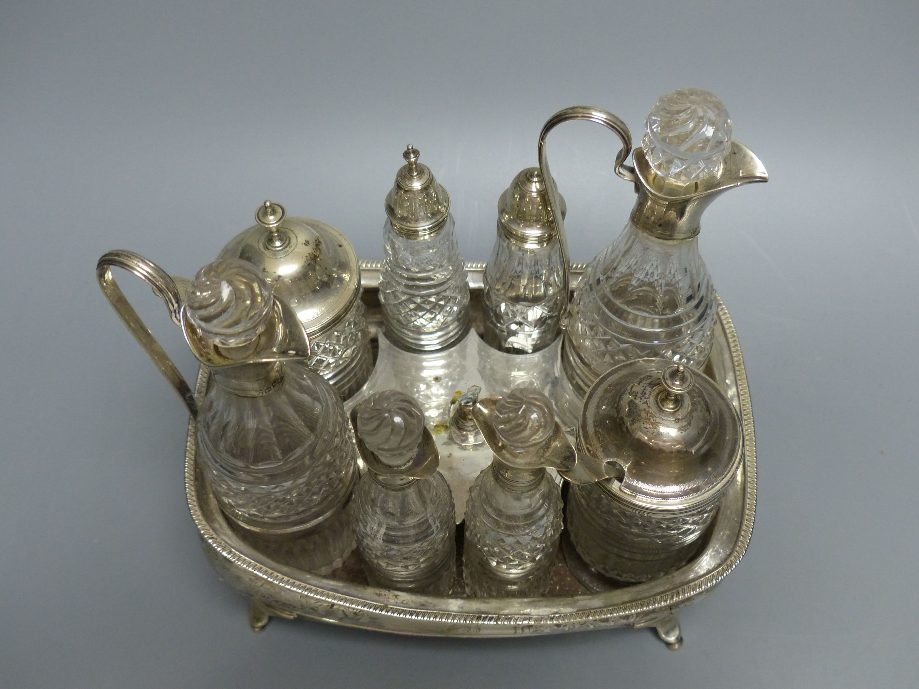 A George III silver cruet stand, with six matching cruets, London 1808, and two associated cruets, handle missing,